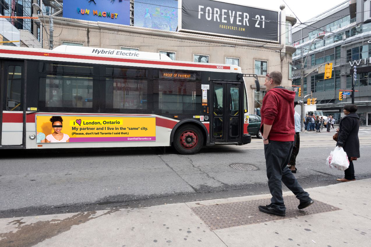 Bus_Partner_in_Same_city An image of a Toronto Transit bus driving past with a Don't Tell Toronto advertisement on the side of it.
